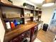 Well-designed laundry room with wooden countertops, shelving, a sink, and red front load washer and dryer at 4414 Hickory Grove Blvd, Greenwood, IN 46143