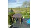 Aerial view of the backyard featuring a sparkling pool, covered patio, and serene green space overlooking the golf course at 4414 Hickory Grove Blvd, Greenwood, IN 46143
