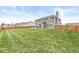 Large backyard with a well-kept lawn, wood fence, and outdoor patio area at 474 Pekin Way, Pendleton, IN 46064