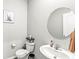 Neutral powder room with a round mirror and a classic pedestal sink for a timeless appeal at 474 Pekin Way, Pendleton, IN 46064
