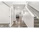 Bright hallway with hardwood flooring, leading to a comfortable living area and staircase at 474 Pekin Way, Pendleton, IN 46064