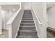 Carpeted staircase with white handrails leads to the upper level, providing easy access to the home's living spaces at 474 Pekin Way, Pendleton, IN 46064