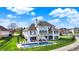 Aerial view of a waterfront home featuring a pool, deck, basketball court, and landscaped lawn at 4883 Snowberry Bay Ct, Carmel, IN 46033