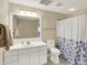 Neutral-toned bathroom with white vanity, large mirror, and shower with floral curtain at 4883 Snowberry Bay Ct, Carmel, IN 46033
