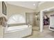 This primary bathroom features a soaking tub and glass shower, and opens to a walk-in closet at 4883 Snowberry Bay Ct, Carmel, IN 46033