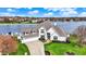 Aerial view of a white brick home with a well-manicured lawn near a tranquil lake at 4883 Snowberry Bay Ct, Carmel, IN 46033