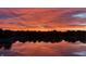 Picturesque lake at sunrise, reflecting vibrant colors and the silhouette of the horizon at 4883 Snowberry Bay Ct, Carmel, IN 46033