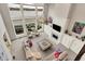 Open-concept living room with fireplace, lake views, and access to an outdoor patio at 4883 Snowberry Bay Ct, Carmel, IN 46033
