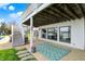 Outdoor patio area with stairs and large rug; windows reflect the pool and backyard at 4883 Snowberry Bay Ct, Carmel, IN 46033