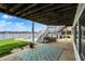 Spacious covered patio featuring outdoor lounge area with pool and lake views at 4883 Snowberry Bay Ct, Carmel, IN 46033