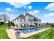 Exterior shot of home with a beautiful pool, plenty of lounge chairs, and a basketball hoop at 4883 Snowberry Bay Ct, Carmel, IN 46033