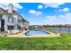 Backyard view of pool, lake, home, and lounging chairs on a bright sunny day at 4883 Snowberry Bay Ct, Carmel, IN 46033