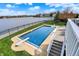 Lakefront pool features a diving board and serene water views, surrounded by lush green grass at 4883 Snowberry Bay Ct, Carmel, IN 46033