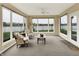 Bright sunroom with large windows overlooking the lake and an adjacent door to the outdoors at 4883 Snowberry Bay Ct, Carmel, IN 46033