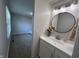 Bright bathroom with round mirror, modern vanity, and view to a bedroom creating a seamless flow at 4912 Cayman Ct, Columbus, IN 47203