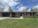 Charming brick home featuring a well-maintained lawn and a dark-colored two-car garage at 4912 Cayman Ct, Columbus, IN 47203