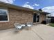 Chairs and a table on a concrete patio next to a brick house at 4912 Cayman Ct, Columbus, IN 47203