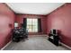 Spacious bedroom featuring red walls, neutral carpet, and a bright window for natural light at 4916 Franklin Villas Dr, Indianapolis, IN 46237
