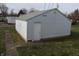 Exterior view of a white, detached garage with an adjacent concrete walkway, nestled in a grassy backyard at 548 S Vine St, Indianapolis, IN 46241