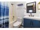 Updated bathroom featuring a shower-tub combo, modern blue vanity, and stylish fixtures at 5634 Wynridge Ct, Indianapolis, IN 46235