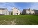 Green backyard with lush grass and view of the back exterior of the home at 5828 Long Lake Ln, Indianapolis, IN 46235