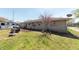 Backyard featuring a well-maintained lawn, garden area, and mature tree at 594 Daugherty St, Columbus, IN 47201