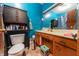 Bathroom featuring a wood vanity with a beige countertop, blue walls and toilet with storage at 594 Daugherty St, Columbus, IN 47201