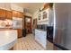Functional kitchen with a stainless steel refrigerator, wooden cabinets, and a black and white tile floor at 594 Daugherty St, Columbus, IN 47201
