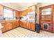 Quaint kitchen featuring wood cabinets, black and white tile flooring, and a door to another room at 594 Daugherty St, Columbus, IN 47201