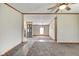 Spacious living room with open floor plan, carpet, and ceiling fan, leading to dining area and kitchen at 611 Victor Pl, Shelbyville, IN 46176