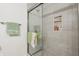 Modern bathroom shower featuring gray tiled walls and shower caddy niche with sliding glass door at 622 Conner Creek Dr, Fishers, IN 46038