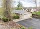 Inviting tan home featuring a large garage, a metal roof, an asphalt driveway and a small landscaped yard at 6948 Eagle Dr, Nineveh, IN 46164