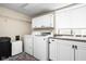 Bright laundry room featuring modern appliances, upper cabinets, and a sink at 6948 Eagle Dr, Nineveh, IN 46164
