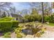Backyard featuring a tranquil pond surrounded by lush landscaping, rocks, and foliage at 7124 Purdy St, Indianapolis, IN 46268