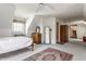 Well-lit bedroom featuring a comfortable bed, carpeted floors, and a view into an adjoining room at 7124 Purdy St, Indianapolis, IN 46268