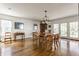 Sunlit dining room featuring hardwood floors, a classic chandelier, and French doors to the backyard at 7124 Purdy St, Indianapolis, IN 46268
