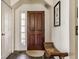 Cozy foyer featuring a dark wood door, tiled floor, and decorative chair at 7124 Purdy St, Indianapolis, IN 46268