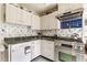 Classic white kitchen featuring stainless steel appliances, tiled backsplash, and modern finishes at 7124 Purdy St, Indianapolis, IN 46268