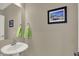 Half bathroom with a pedestal sink, towel and coastal themed wall art at 741 Bates St, Indianapolis, IN 46202