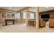 Spacious basement with foosball table, ample seating, and a stylish wood-paneled wall with a large TV at 7613 W Stonegate Dr, Zionsville, IN 46077