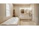 The well-lit bathroom boasts a soaking tub, double vanity, and a separate shower, offering a spa-like retreat at home at 7613 W Stonegate Dr, Zionsville, IN 46077