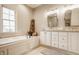 Bright bathroom features a soaking tub, double vanity, and elegant finishes, creating a luxurious bathing experience at 7613 W Stonegate Dr, Zionsville, IN 46077