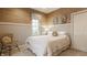 Bright bedroom with grasscloth wallpaper, white bedding, accent chair, and natural light at 7613 W Stonegate Dr, Zionsville, IN 46077