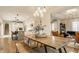 Open concept dining area with hardwood floors, adjacent to a kitchen with a large island at 7613 W Stonegate Dr, Zionsville, IN 46077