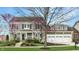 Charming two-story home with a three-car garage and beautifully landscaped front yard at 7613 W Stonegate Dr, Zionsville, IN 46077