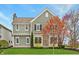 Charming two-story home with light green siding, beautiful landscaping, and a well-manicured lawn at 7613 W Stonegate Dr, Zionsville, IN 46077