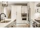 Well-lit kitchen features stainless appliances, custom cabinetry, and a seamless transition to the staircase at 7613 W Stonegate Dr, Zionsville, IN 46077