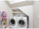 Laundry room featuring a modern washer and dryer setup with shelving above, great for storage at 7613 W Stonegate Dr, Zionsville, IN 46077