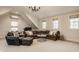 Spacious living room with vaulted ceilings, brown leather sectional, and abundant natural light at 7613 W Stonegate Dr, Zionsville, IN 46077