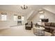 Spacious living room with vaulted ceilings, brown leather sectional, and stylish chandelier at 7613 W Stonegate Dr, Zionsville, IN 46077